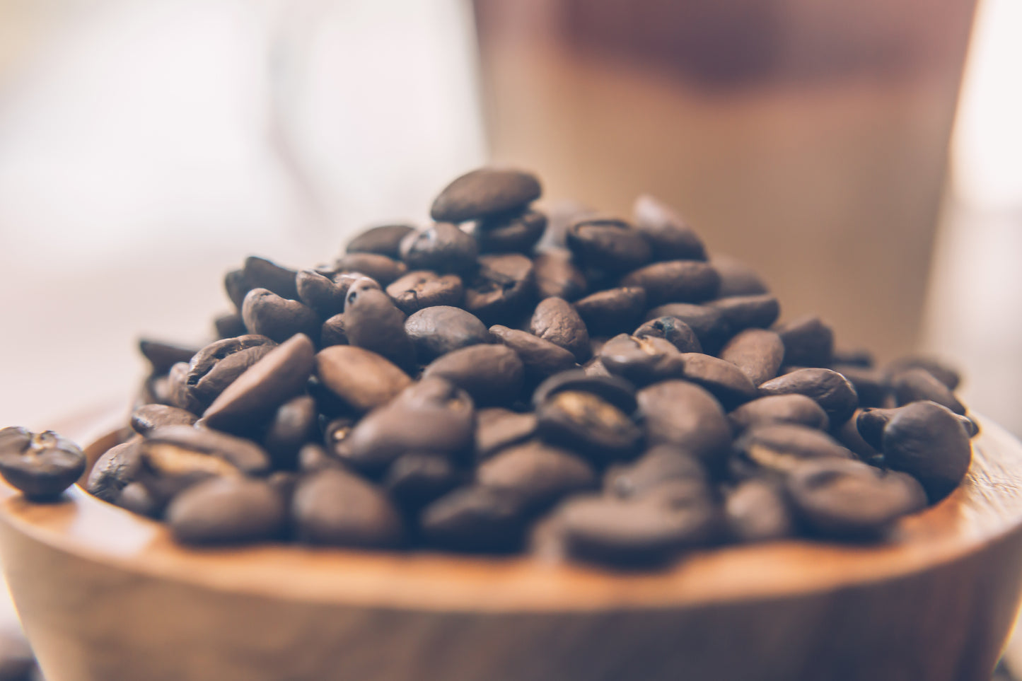 Close-up of UfuKoffee chocolate tasting coffee beans piled in a wooden bowl