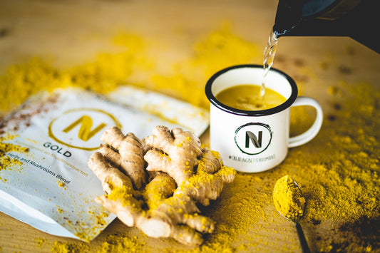 Pouring hot water into a mug with ginger and mushroom blend for a healthy beverage.