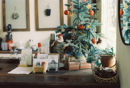 Warm and inviting Christmas home setup featuring a decorated tree, gifts, and greeting cards.